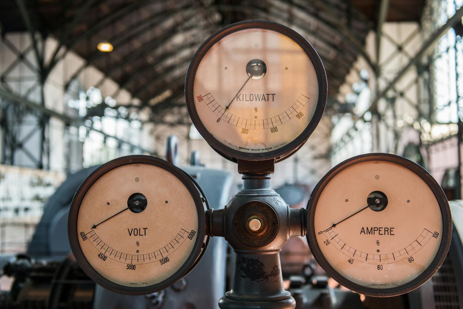 Close-up of vintage kilowatt, volt, and ampere gauges in Essen's industrial setting.